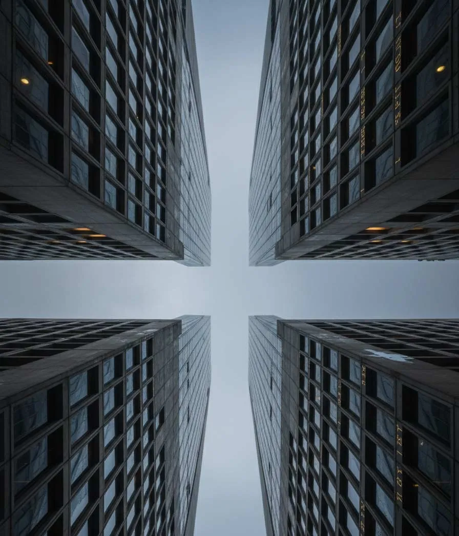 Looking up between glass towers toward the sky